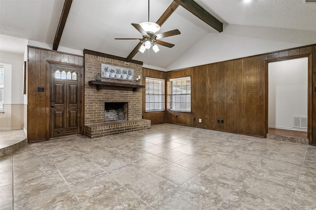 2526 Axminster Dr, Grand Prairie, TX 75050 - unfurnished living room featuring wooden walls, ceiling fan, healthy amount of natural light, a brick fireplace, and a textured ceiling