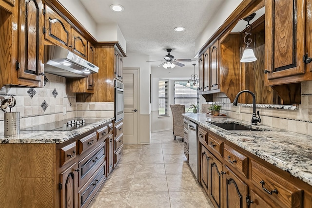 2526 Axminster Dr, Grand Prairie, TX 75050 - kitchen featuring under cabinet range hood, appliances with stainless steel finishes, ceiling fan, light stone countertops, and tasteful backsplash