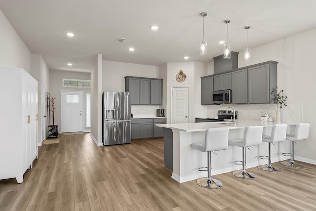 3401 Beutel Rd, Lorena, TX 76655 - kitchen featuring appliances with stainless steel finishes, gray cabinets, a peninsula, light wood-type flooring, and recessed lighting