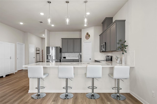 3401 Beutel Rd, Lorena, TX 76655 - kitchen with stainless steel appliances, gray cabinets, tasteful backsplash, a peninsula, and light wood-style flooring