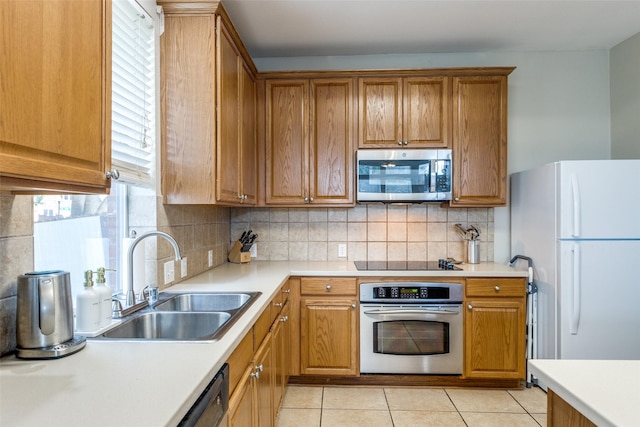 11398 Pear Ridge Dr, Frisco, TX 75035 - kitchen featuring appliances with stainless steel finishes, light tile patterned flooring, light countertops, decorative backsplash, and brown cabinetry