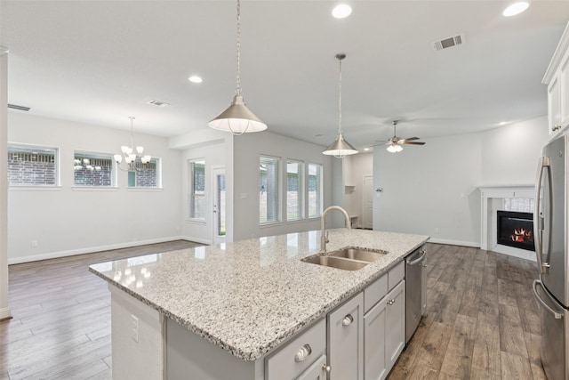 905 Plaza Ln, Argyle, TX 76226 - kitchen with appliances with stainless steel finishes, recessed lighting, open floor plan, an island with sink, and wood finished floors