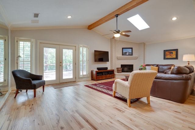 2086 Breezywood Dr, Flower Mound, TX 75022 - living area featuring healthy amount of natural light, light wood finished floors, a skylight, a brick fireplace, and crown molding