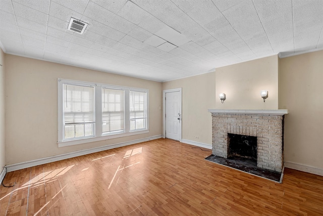 526 N 16th St, Waco, TX 76707 - unfurnished living room with wood finished floors, a brick fireplace, and ornamental molding
