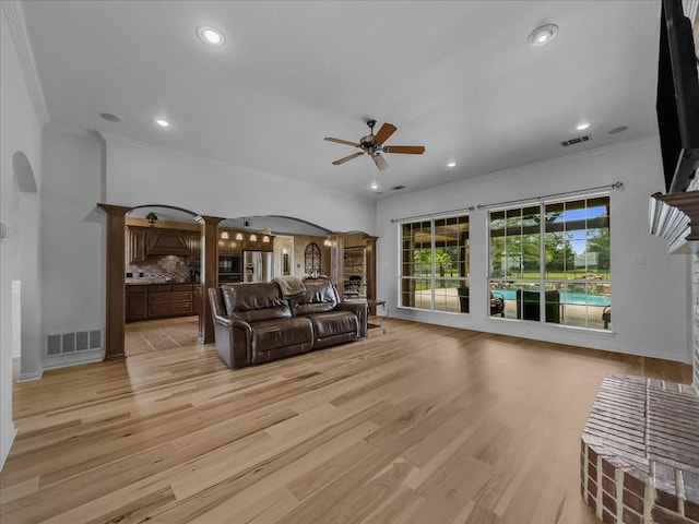 10353 W Dublin Dr, Forney, TX 75126 - living room featuring arched walkways, ceiling fan, ornamental molding, light wood finished floors, and recessed lighting