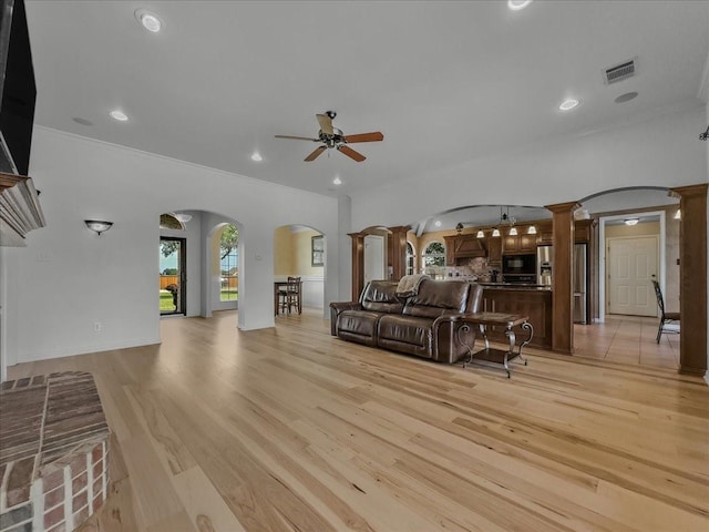 10353 W Dublin Dr, Forney, TX 75126 - living room with arched walkways, a ceiling fan, ornamental molding, light wood-type flooring, and recessed lighting