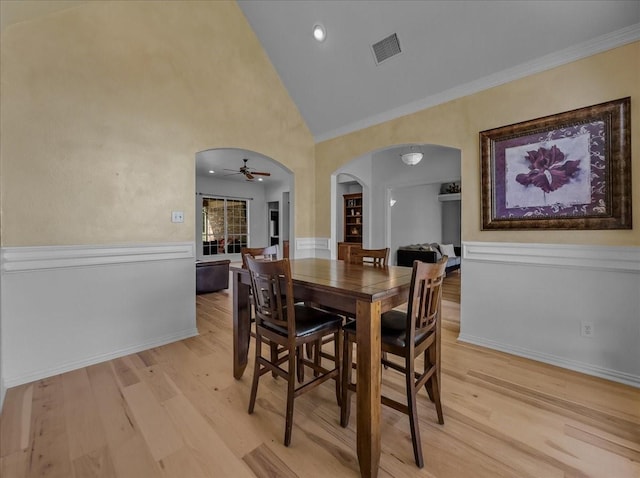 10353 W Dublin Dr, Forney, TX 75126 - dining area with arched walkways, light wood finished floors, a ceiling fan, crown molding, and wainscoting