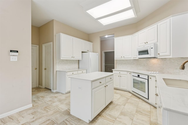 4069 White Porch Rd, Plano, TX 75024 - kitchen featuring white appliances, a kitchen island, backsplash, white cabinetry, and light countertops