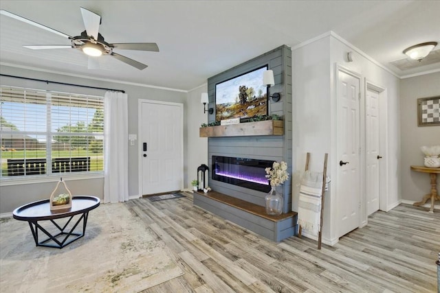 900 Amy Way, Bonham, TX 75418 - entrance foyer with crown molding, wood finished floors, a glass covered fireplace, and ceiling fan