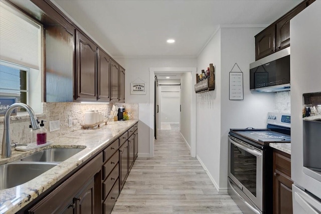 900 Amy Way, Bonham, TX 75418 - kitchen with stainless steel appliances, tasteful backsplash, dark brown cabinets, light wood-style floors, and light stone counters