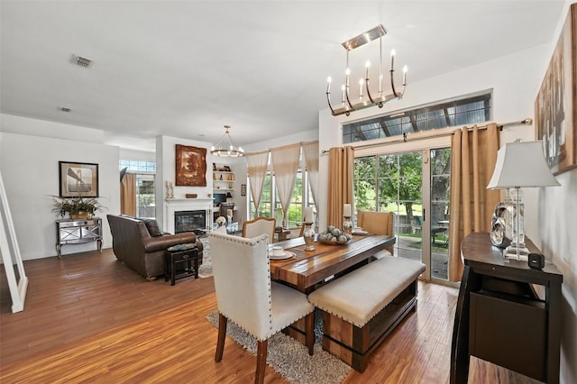 8311 Paxson Trl, Dallas, TX 75249 - dining area with a chandelier, light wood-type flooring, and a glass covered fireplace