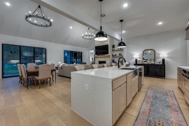 11405 Antler Ridge Way, Argyle, TX 76226 - kitchen with a chandelier, light wood-style flooring, vaulted ceiling, a fireplace, and pendant lighting