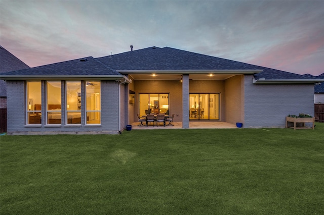 11405 Antler Ridge Way, Argyle, TX 76226 - back of property at dusk with brick siding, roof with shingles, and a patio area