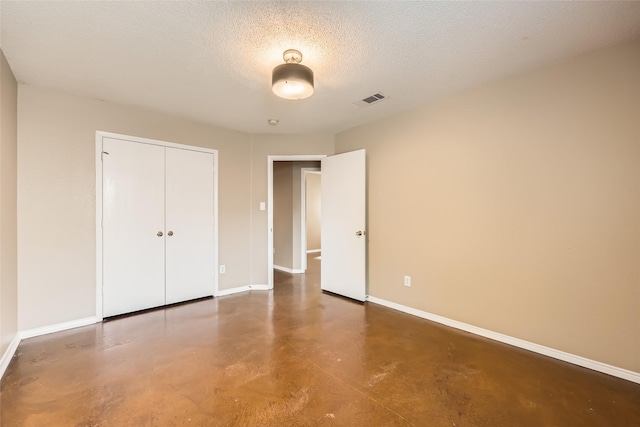7921 Mourning Dove Dr, Arlington, TX 76002 - unfurnished bedroom featuring concrete flooring, a closet, and a textured ceiling