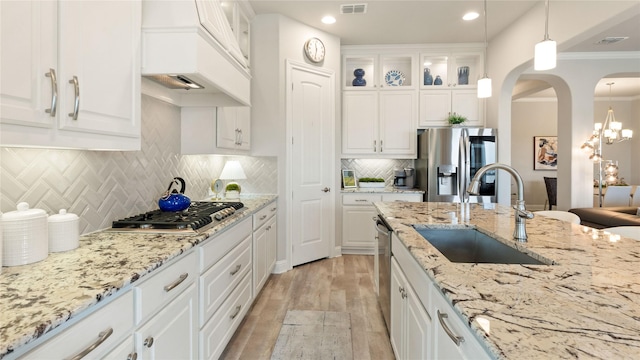 2809 Burgundy Trl, Rowlett, TX 75088 - kitchen featuring stainless steel appliances, arched walkways, light wood-style flooring, white cabinets, and recessed lighting