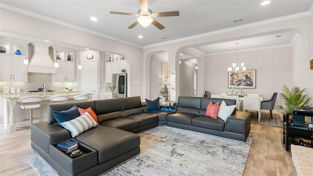 2809 Burgundy Trl, Rowlett, TX 75088 - living room featuring arched walkways, light wood-style floors, a ceiling fan, recessed lighting, and ornamental molding