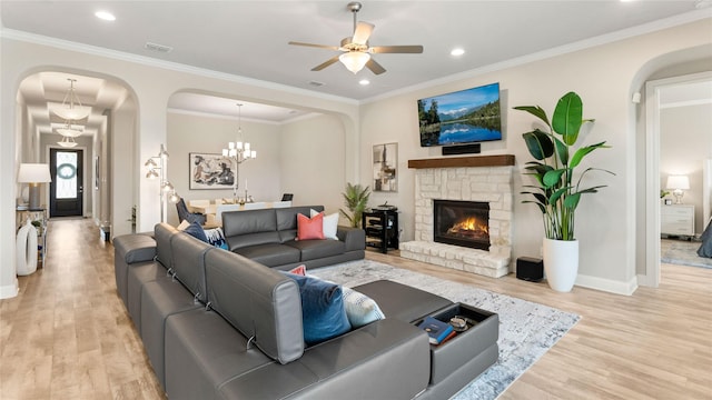 2809 Burgundy Trl, Rowlett, TX 75088 - living area with arched walkways, wood finished floors, a stone fireplace, ornamental molding, and a ceiling fan
