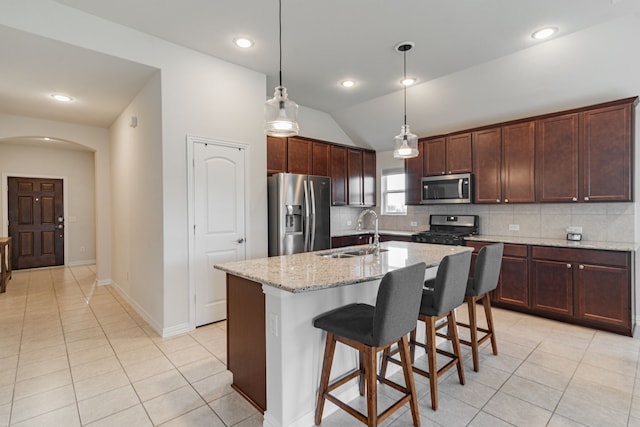 11401 Gale Ridge Ter, Fort Worth, TX 76052 - kitchen with stainless steel appliances, arched walkways, light tile patterned floors, backsplash, and vaulted ceiling