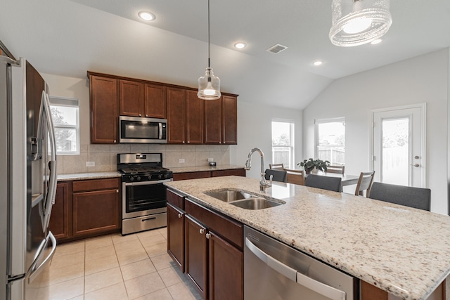 11401 Gale Ridge Ter, Fort Worth, TX 76052 - kitchen featuring stainless steel appliances, vaulted ceiling, a kitchen island with sink, light tile patterned floors, and decorative backsplash