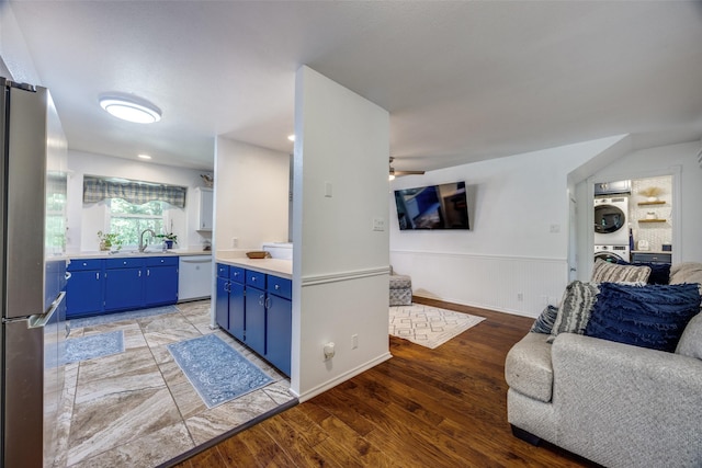 191 Black Forest Dr, Pottsboro, TX 75076 - kitchen featuring open floor plan, freestanding refrigerator, stacked washer / dryer, blue cabinetry, and dishwasher