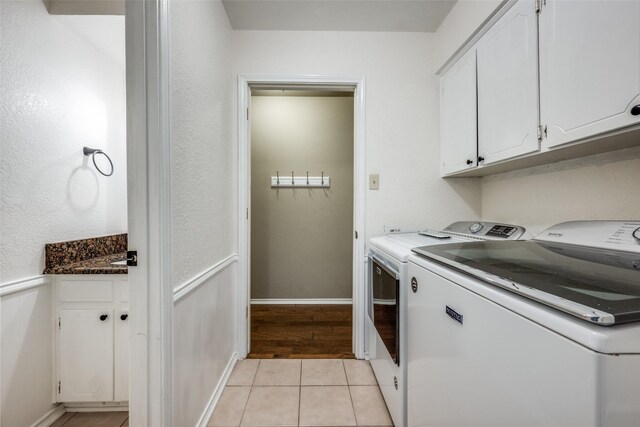 710 Northridge St, Denton, TX 76201 - laundry room with washing machine and dryer, cabinet space, and light tile patterned flooring