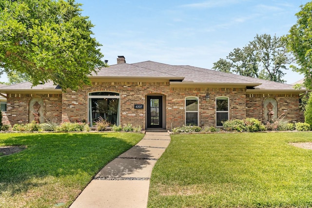 6207 Crested Butte Dr, Dallas, TX 75252 - view of front of property featuring a chimney, a front lawn, brick siding, and roof with shingles