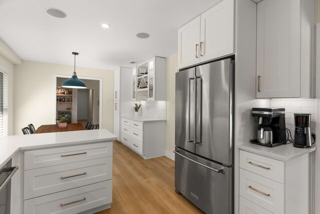 6207 Crested Butte Dr, Dallas, TX 75252 - kitchen with stainless steel appliances, tasteful backsplash, light countertops, white cabinetry, and light wood-type flooring
