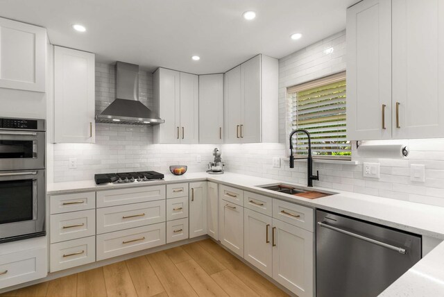 6207 Crested Butte Dr, Dallas, TX 75252 - kitchen featuring stainless steel appliances, wall chimney exhaust hood, light countertops, white cabinetry, and tasteful backsplash