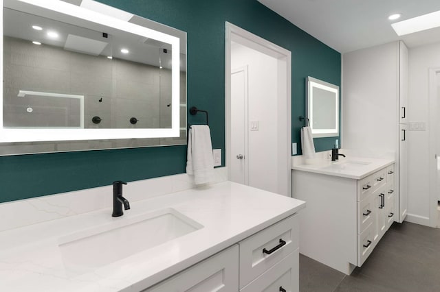 6207 Crested Butte Dr, Dallas, TX 75252 - bathroom featuring walk in shower, two vanities, a skylight, and recessed lighting