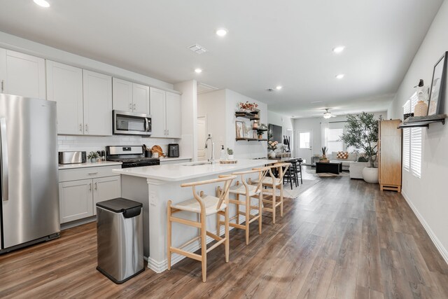 1447 Rolling Fox Dr, Forney, TX 75126 - kitchen with stainless steel appliances, a kitchen bar, decorative backsplash, wood finished floors, and recessed lighting