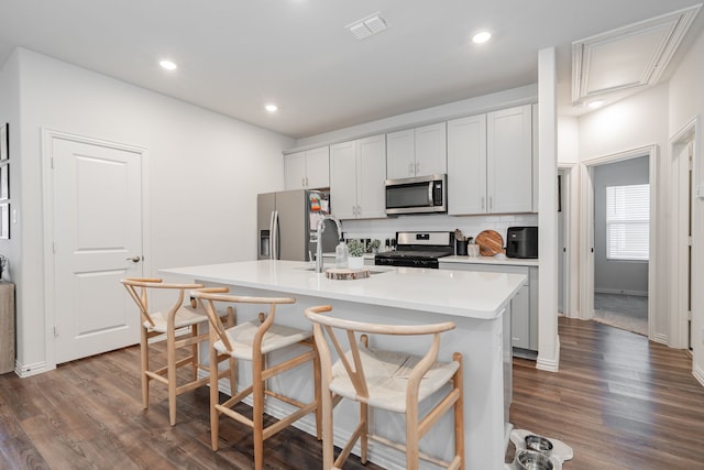 1447 Rolling Fox Dr, Forney, TX 75126 - kitchen with appliances with stainless steel finishes, light countertops, an island with sink, dark wood-type flooring, and recessed lighting