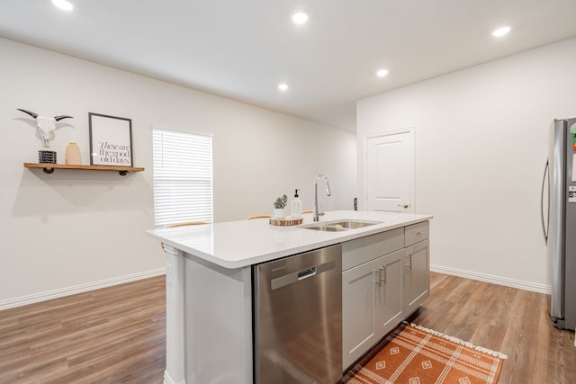 1447 Rolling Fox Dr, Forney, TX 75126 - kitchen with appliances with stainless steel finishes, light wood-style flooring, light countertops, an island with sink, and recessed lighting