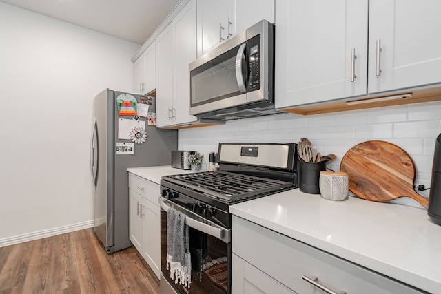 1447 Rolling Fox Dr, Forney, TX 75126 - kitchen with appliances with stainless steel finishes, backsplash, light countertops, and light wood-style floors