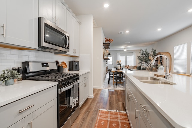 1447 Rolling Fox Dr, Forney, TX 75126 - kitchen featuring appliances with stainless steel finishes, backsplash, light countertops, wood finished floors, and recessed lighting