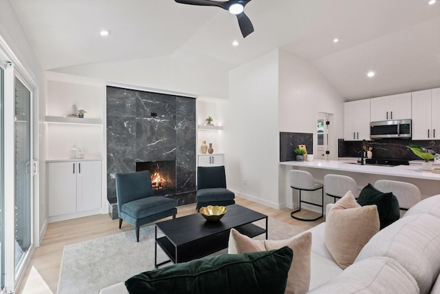 2605 S Glenbrook Dr, Garland, TX 75041 - living room featuring lofted ceiling, light wood-style floors, a fireplace, built in features, and recessed lighting