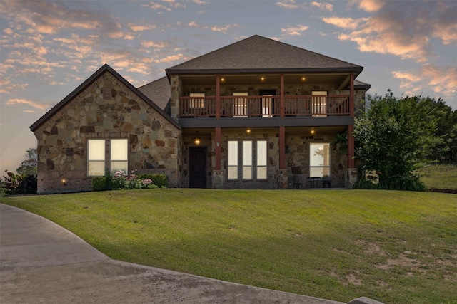 111 Meadow Bridge Dr, Weatherford, TX 76085 - back of house at dusk with stone siding, a lawn, and a balcony
