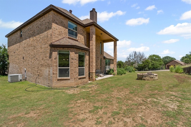 111 Meadow Bridge Dr, Weatherford, TX 76085 - back of house with a fire pit, brick siding, a chimney, a patio area, and a lawn
