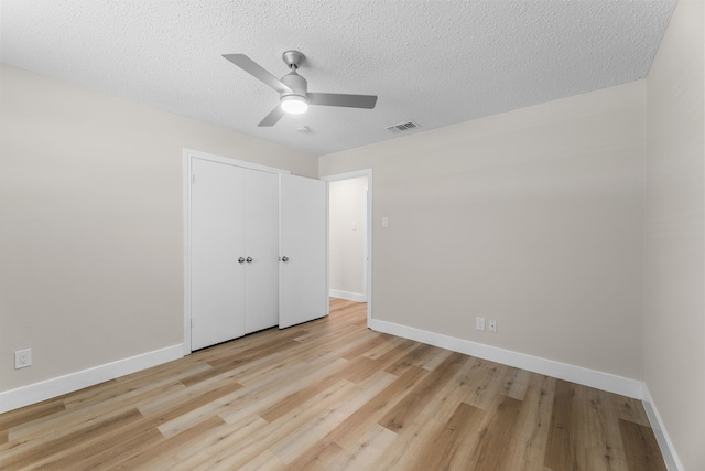 1124 Janell Dr, Irving, TX 75062 - unfurnished bedroom featuring light wood-style floors, a closet, a textured ceiling, and ceiling fan