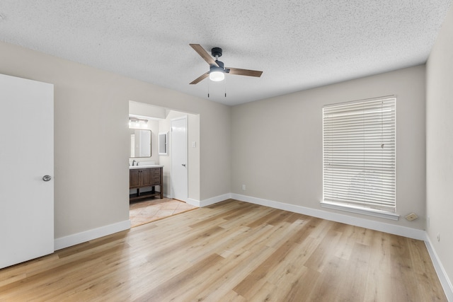 1124 Janell Dr, Irving, TX 75062 - unfurnished bedroom with light wood finished floors, ensuite bath, a textured ceiling, and ceiling fan