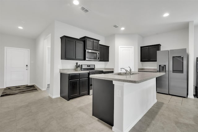 16721 Porterfield Ln, Justin, TX 76247 - kitchen featuring appliances with stainless steel finishes, an island with sink, recessed lighting, and dark cabinetry