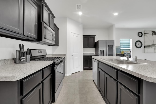 16721 Porterfield Ln, Justin, TX 76247 - kitchen with stainless steel appliances, an island with sink, light countertops, recessed lighting, and light tile patterned floors