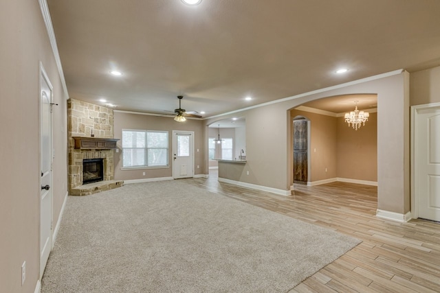 924 Via Barcelona, Mesquite, TX 75150 - unfurnished living room featuring crown molding, a chandelier, arched walkways, a fireplace, and a ceiling fan