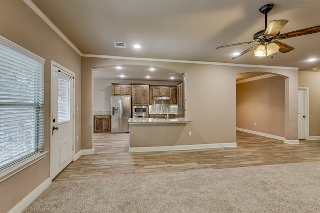 924 Via Barcelona, Mesquite, TX 75150 - kitchen with stainless steel appliances, arched walkways, crown molding, ceiling fan, and light wood-style flooring