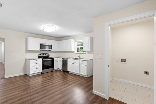 431 W Texas St, Denison, TX 75020 - kitchen featuring stainless steel appliances, dark wood-type flooring, white cabinetry, tasteful backsplash, and light stone countertops