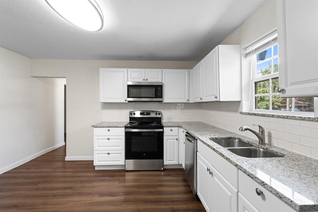 431 W Texas St, Denison, TX 75020 - kitchen with stainless steel appliances, backsplash, white cabinets, dark wood-type flooring, and light stone counters