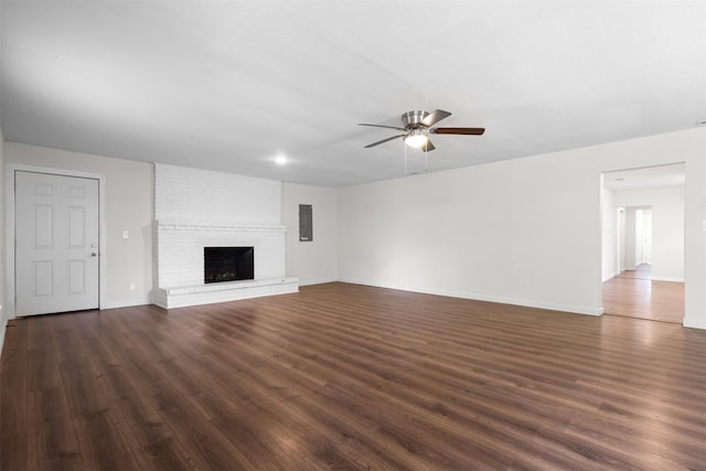 431 W Texas St, Denison, TX 75020 - unfurnished living room with ceiling fan, dark wood-type flooring, and a brick fireplace