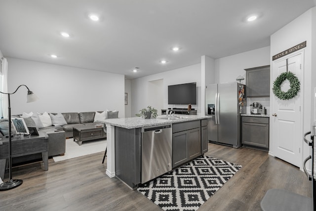 3216 Everly Dr, Fate, TX 75189 - kitchen with appliances with stainless steel finishes, open floor plan, a kitchen island with sink, dark wood finished floors, and recessed lighting