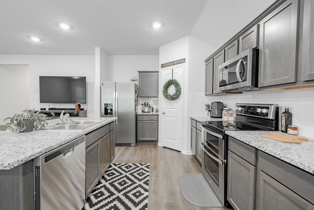 3216 Everly Dr, Fate, TX 75189 - kitchen featuring stainless steel appliances, decorative backsplash, light wood-style floors, gray cabinetry, and recessed lighting