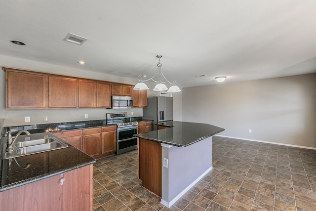 2153 Valley Forge Trl, Fort Worth, TX 76177 - kitchen featuring stainless steel appliances, a kitchen island, recessed lighting, hanging light fixtures, and brown cabinets