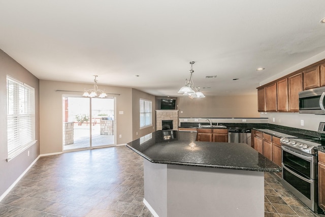 2153 Valley Forge Trl, Fort Worth, TX 76177 - kitchen with appliances with stainless steel finishes, open floor plan, a fireplace, a chandelier, and hanging light fixtures